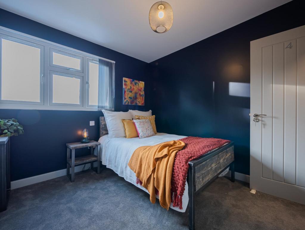 This inviting double bedroom features a cozy be...