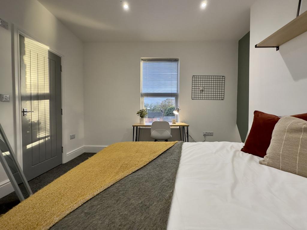 A bright and inviting double bedroom with a coz...
