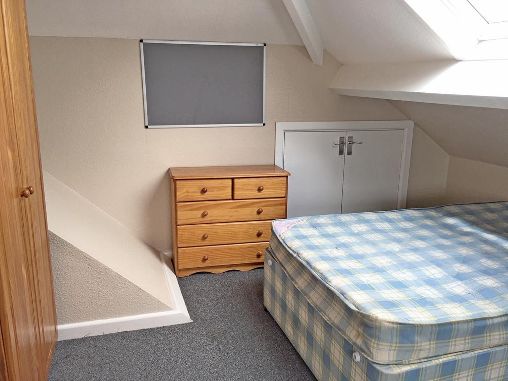 Cozy double bedroom featuring a comfortable bed...