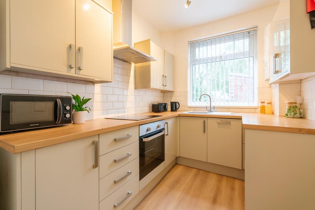 Bright, modern kitchen with light wood countert...