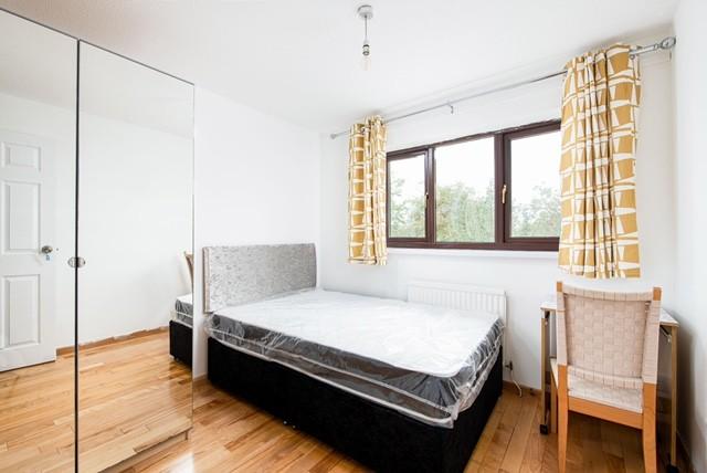 This cozy double bedroom features warm wooden f...