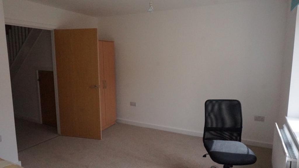 A cozy double bedroom featuring a fitted wardro...