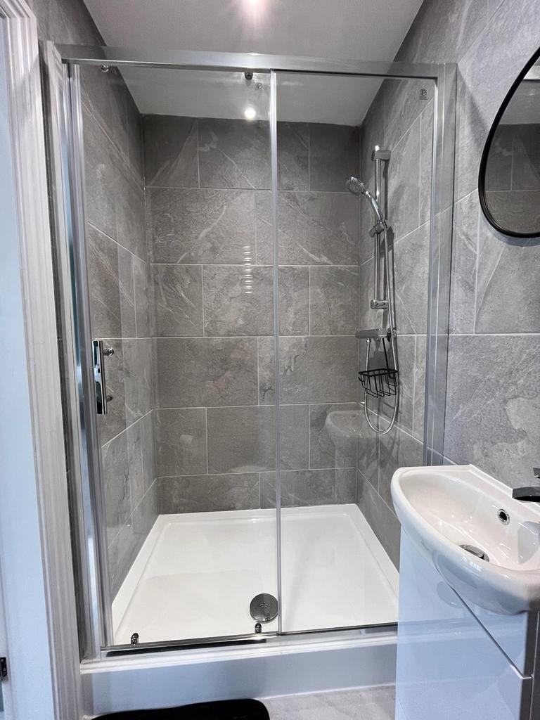 Modern bathroom featuring a sleek glass shower ...