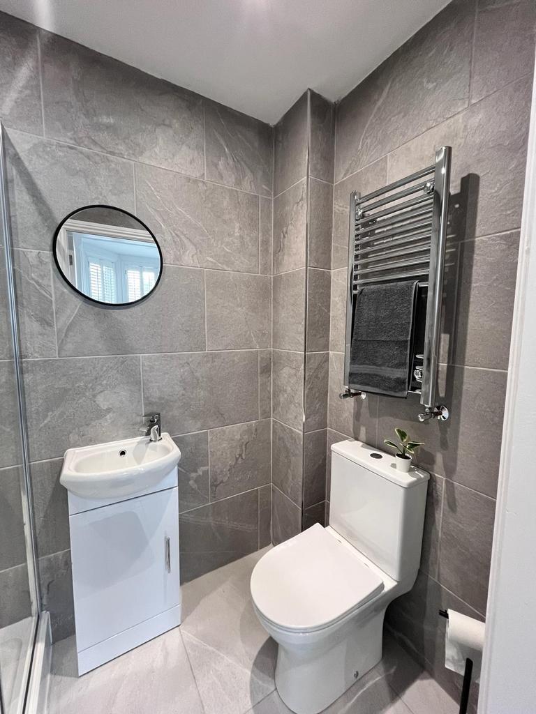 Modern bathroom featuring sleek grey tiles, a s...