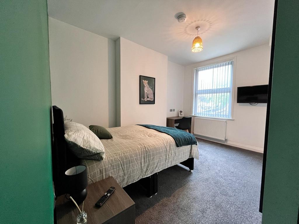 Spacious double bedroom featuring a cozy ambian...