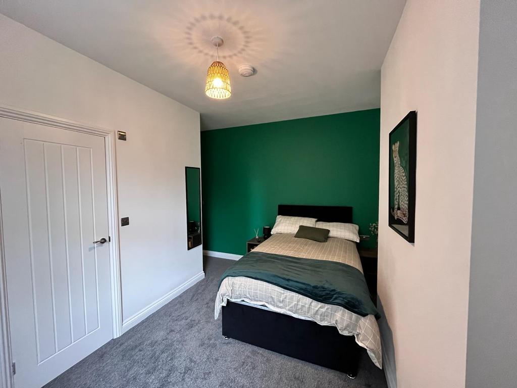 This stylish double bedroom features a cozy atm...