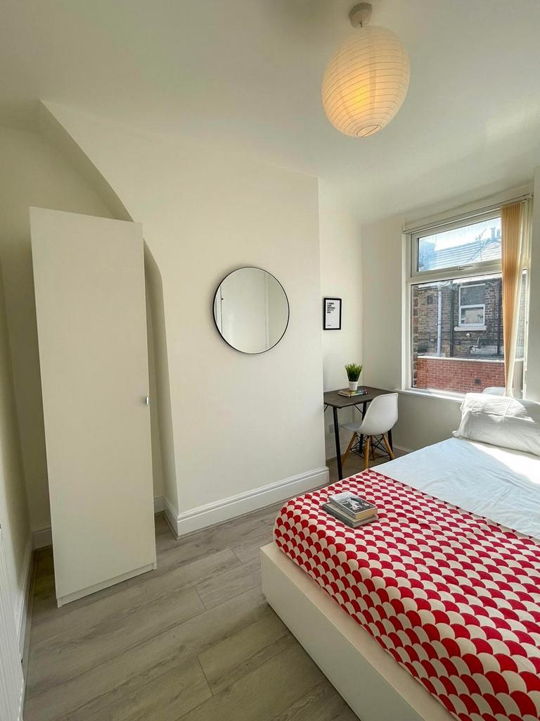 A bright and inviting double bedroom with moder...