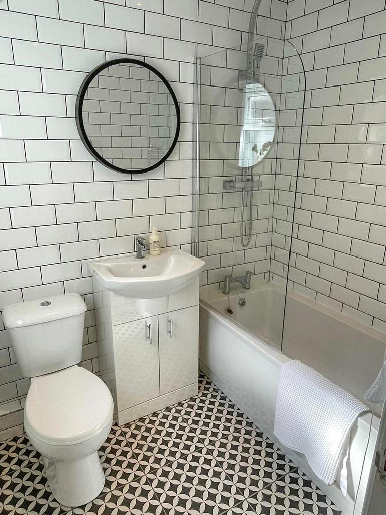 A modern and stylish bathroom featuring a bath ...