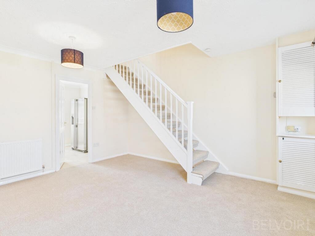 A spacious living room with soft carpeting and ...
