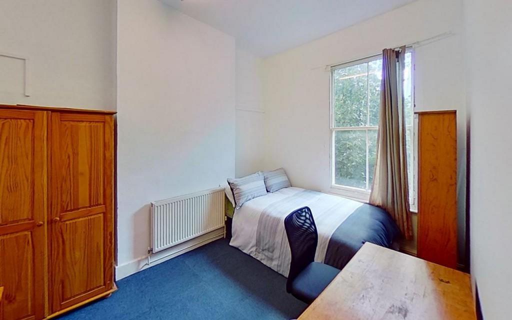 This inviting double bedroom features a comfort...
