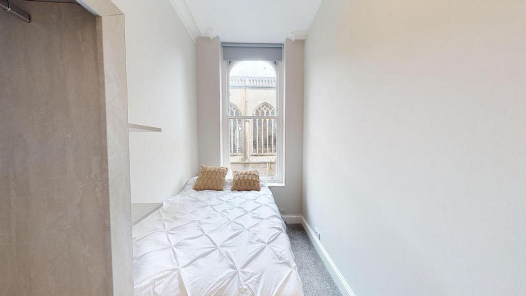 A bright and tidy double bedroom featuring larg...