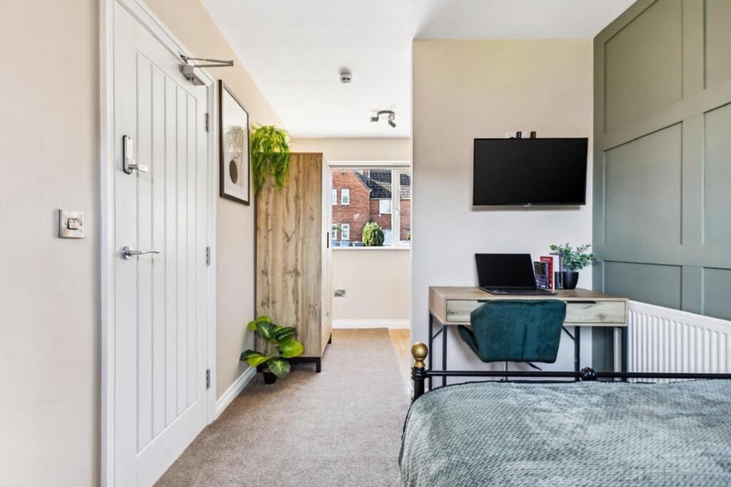 This stylish double bedroom features a comforta...