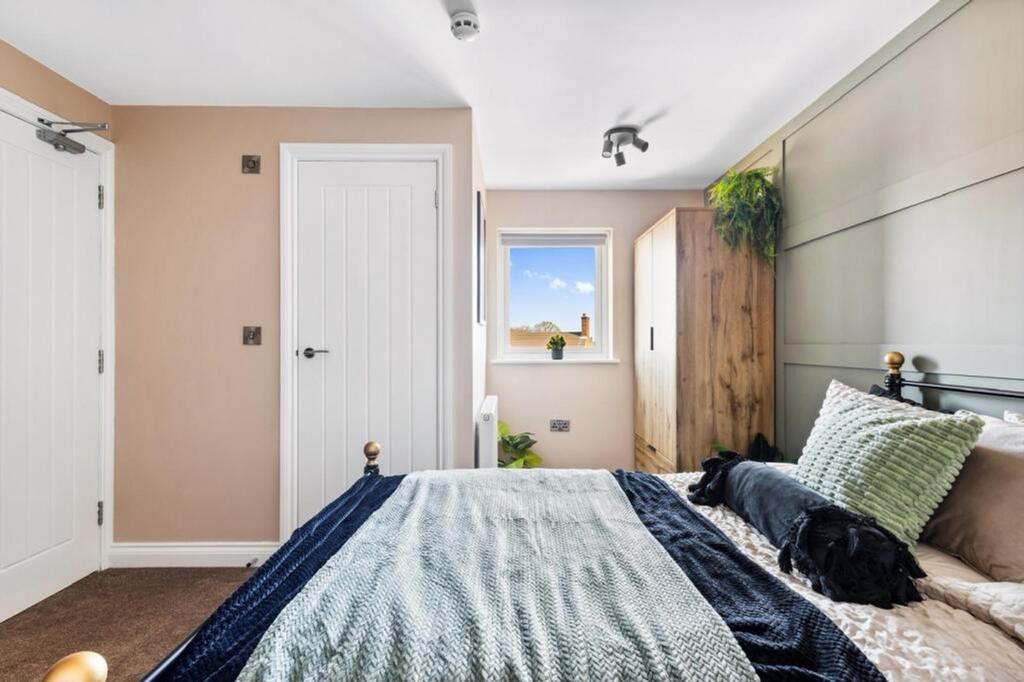 This charming double bedroom features a cozy de...