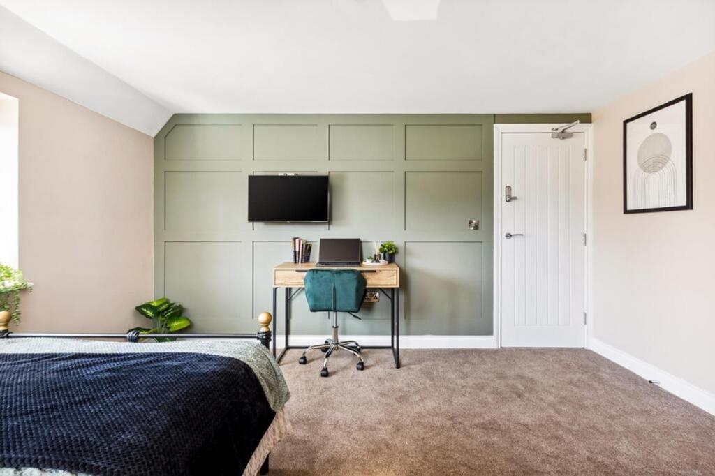 This inviting double bedroom features a cozy at...