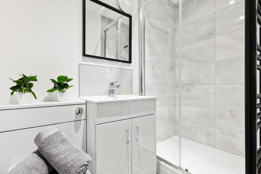 This sleek bathroom features a modern shower an...