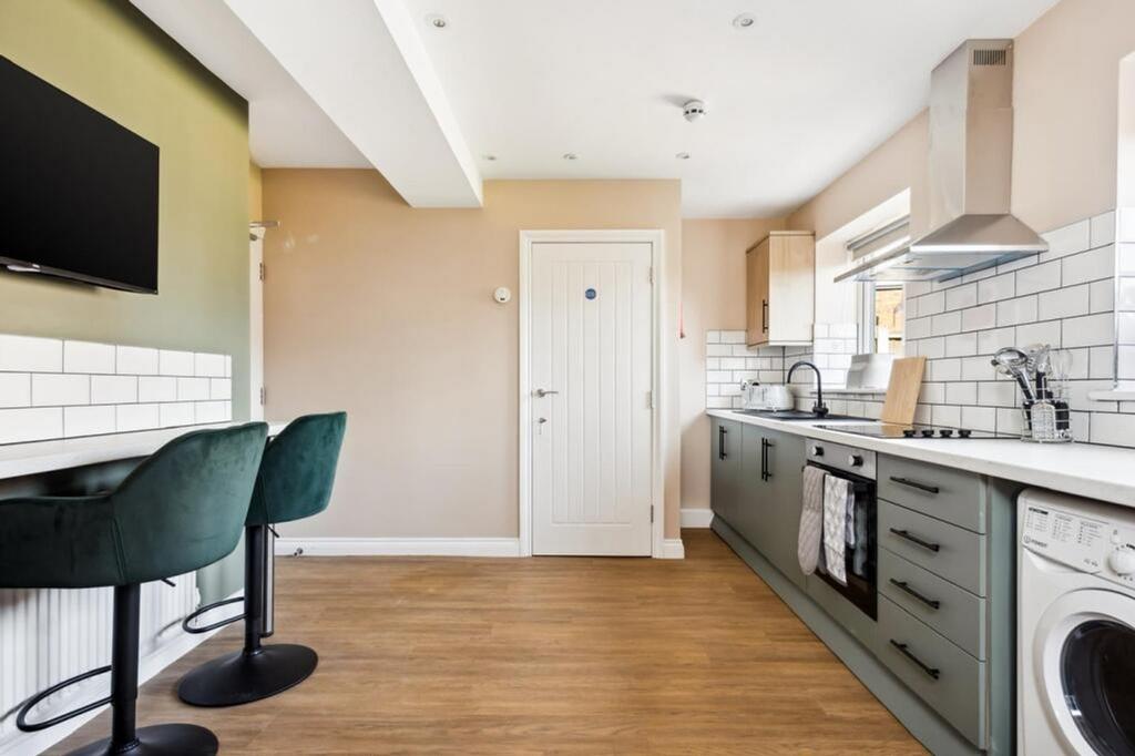 Modern kitchen featuring stylish cabinetry, amp...