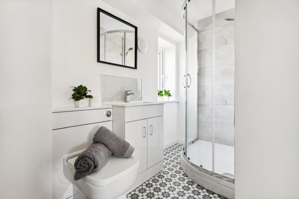 This modern bathroom features a spacious shower...