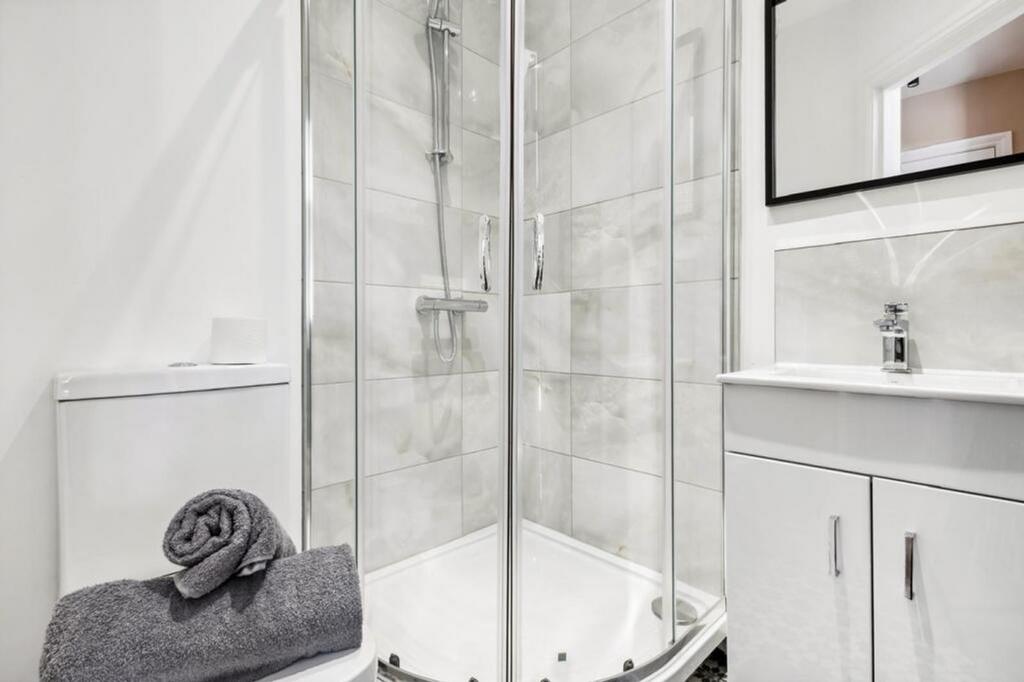 A modern bathroom featuring a sleek shower with...