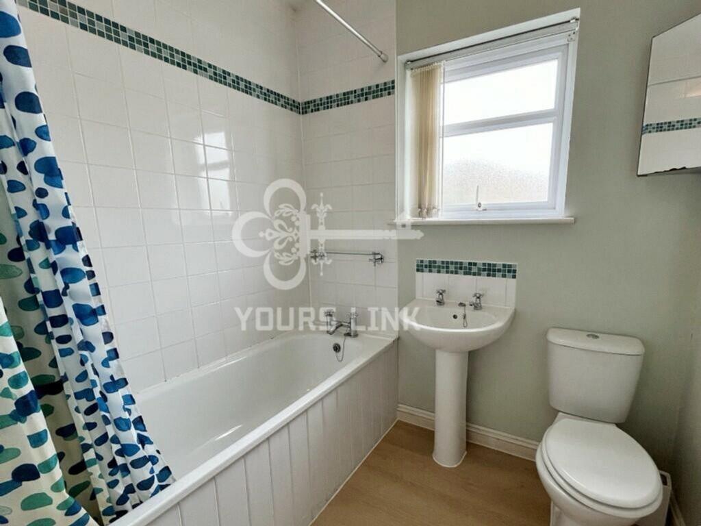 A clean and bright bathroom featuring a spaciou...