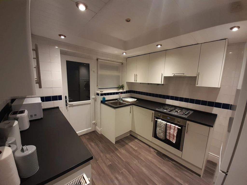A modern kitchen featuring sleek cabinetry, an ...