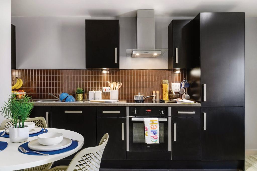 This modern kitchen features sleek black cabine...