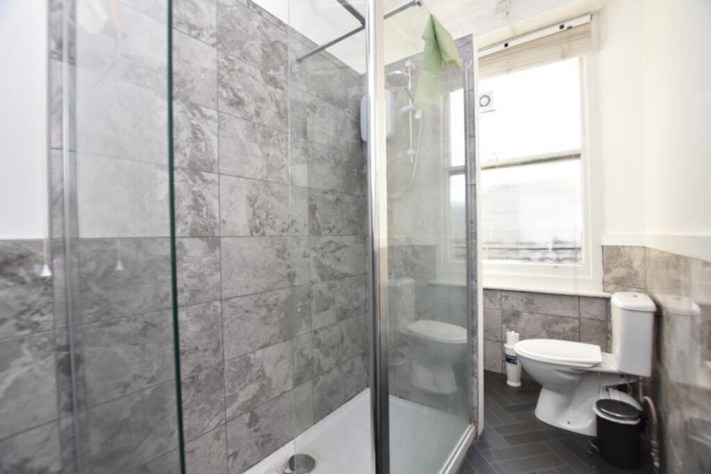 A modern bathroom featuring sleek tiles, a spac...