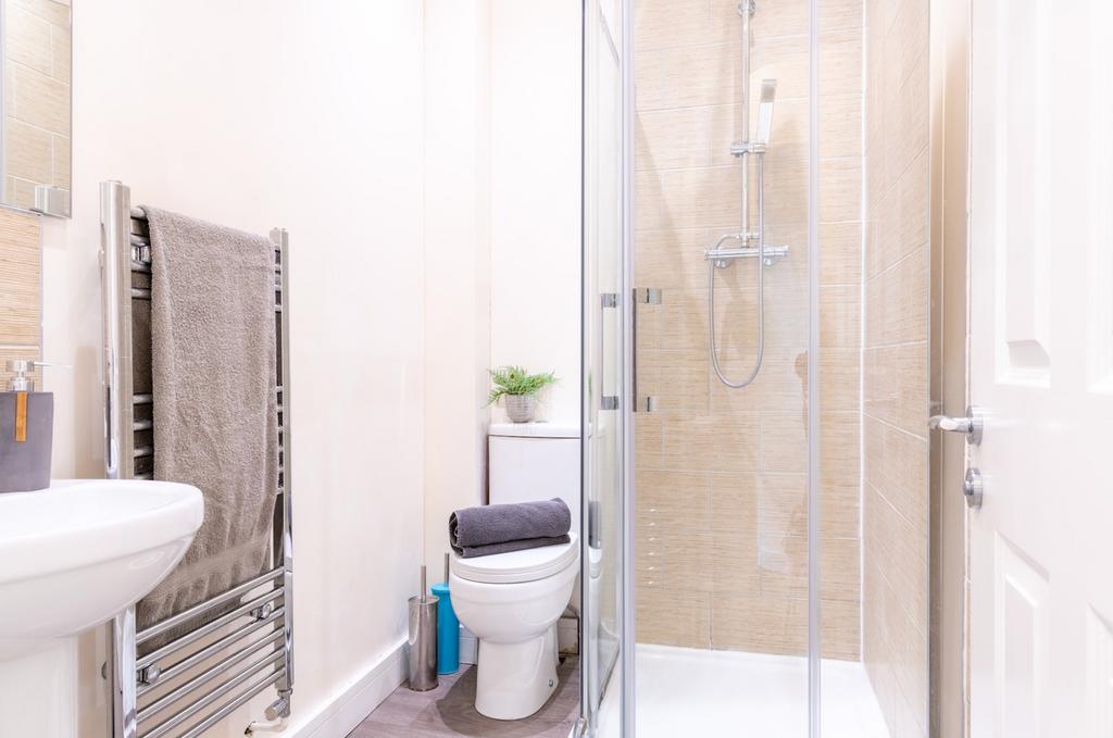 A modern bathroom featuring a sleek glass showe...