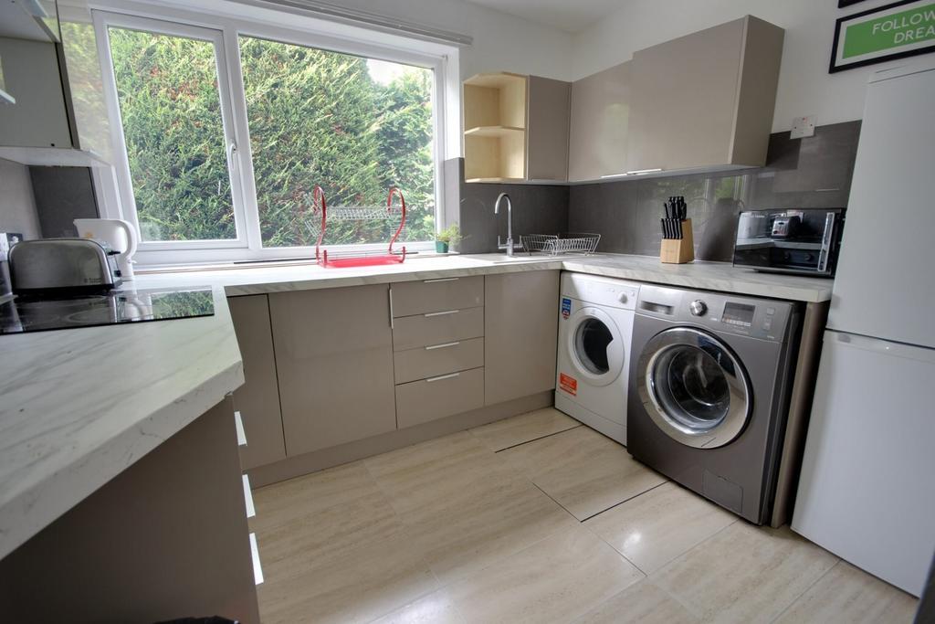 A modern and tidy kitchenette with ample natura...