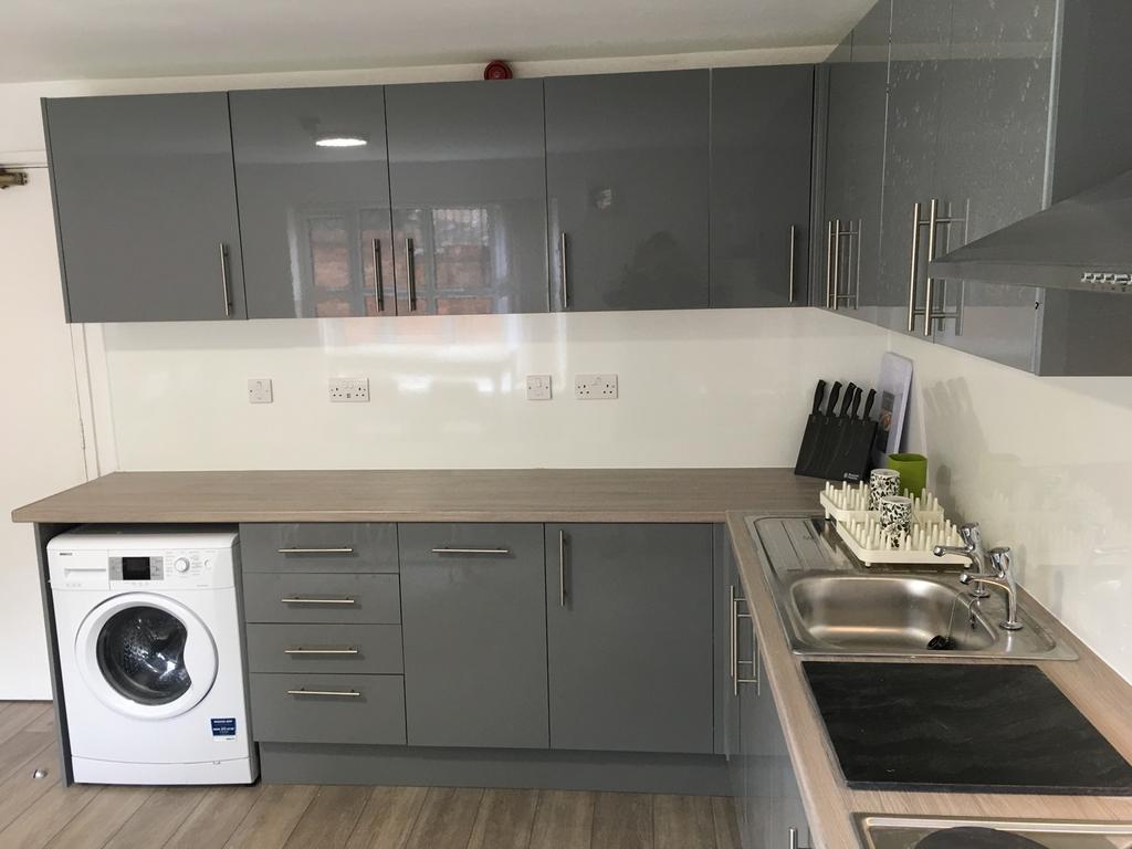 A modern and sleek kitchen featuring ample stor...
