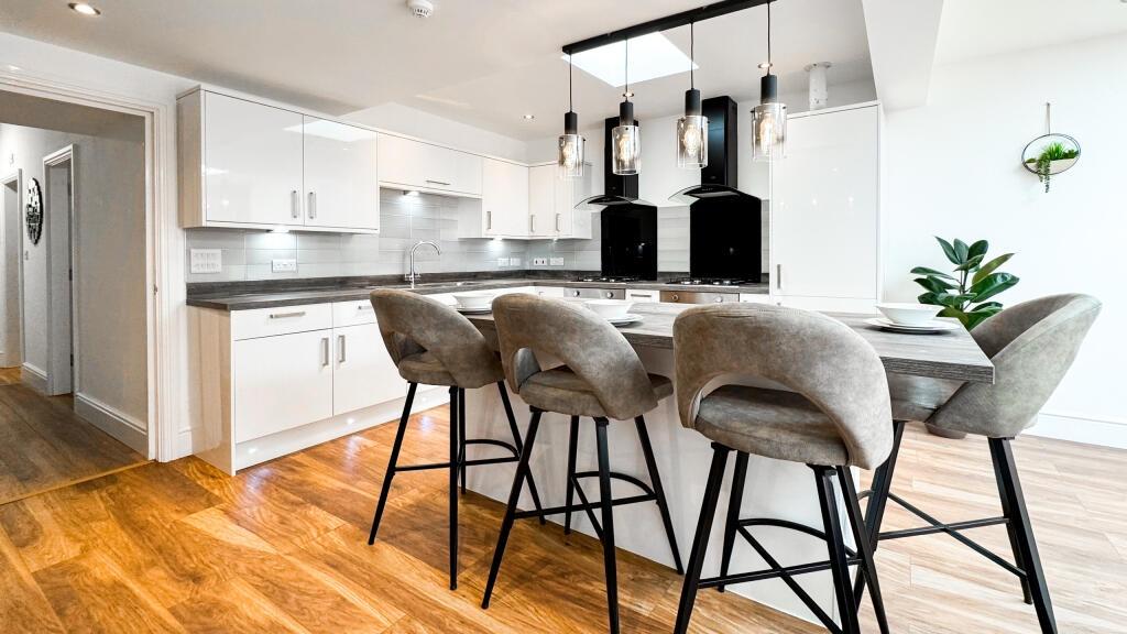 A modern kitchen featuring sleek cabinetry and ...