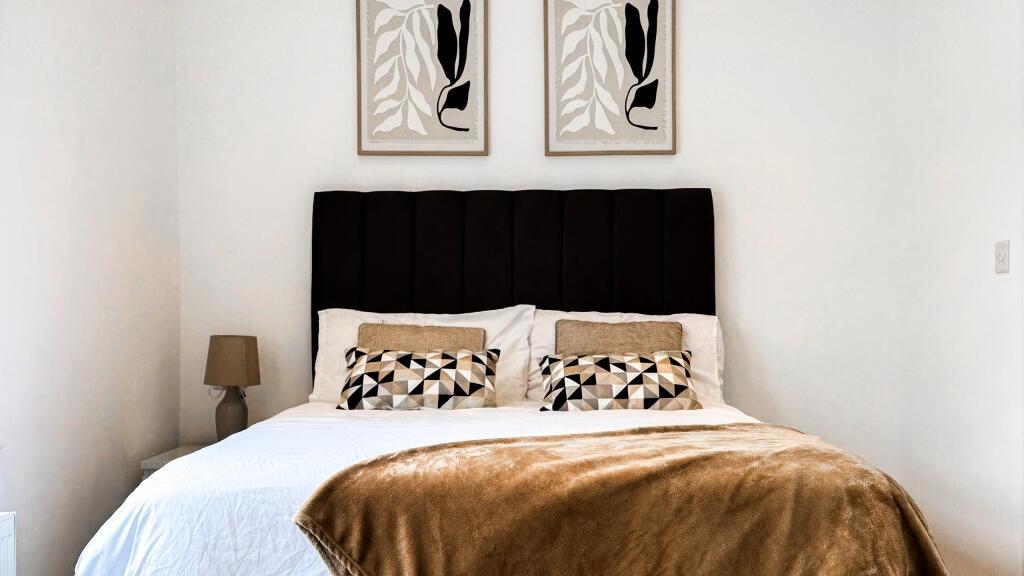 This inviting double bedroom features a cozy am...