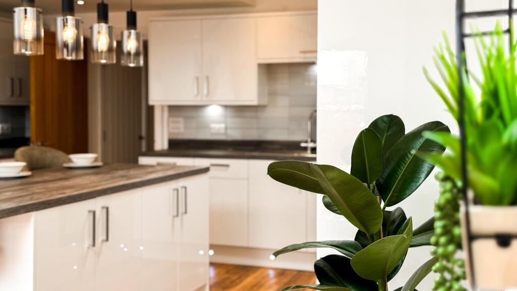 A modern kitchen featuring sleek white cabinetr...