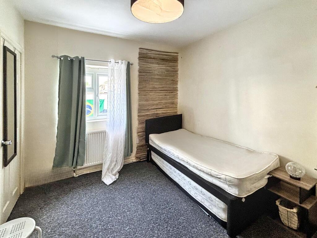 Cozy single bedroom featuring a comfortable bed...