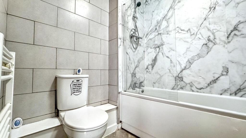 This stylish bathroom features elegant marble a...