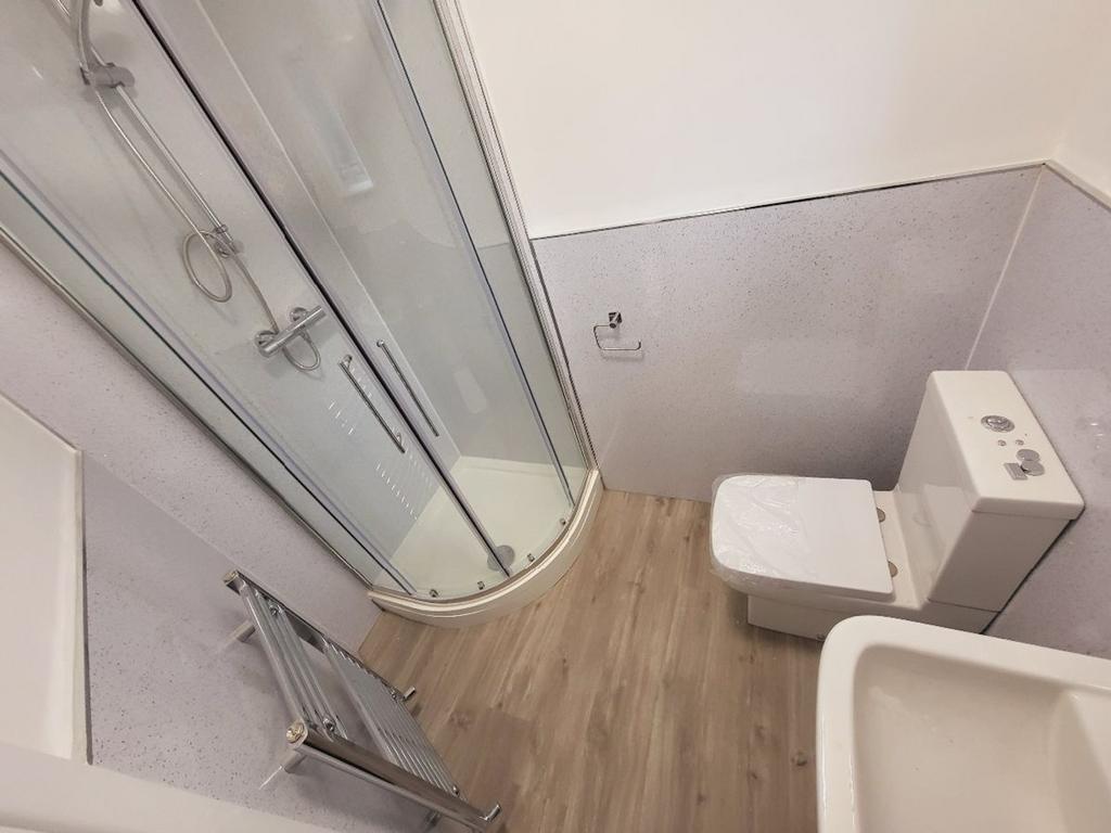 This modern bathroom features a spacious shower...