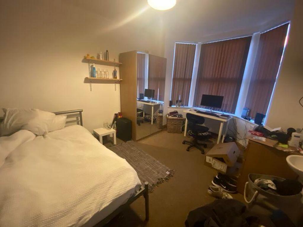 A spacious double bedroom with ample natural li...