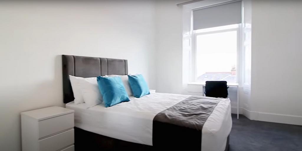 A bright and clean double bedroom featuring a c...