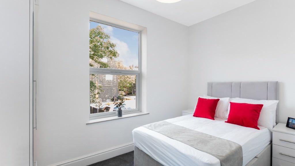 This inviting double bedroom features a cozy de...
