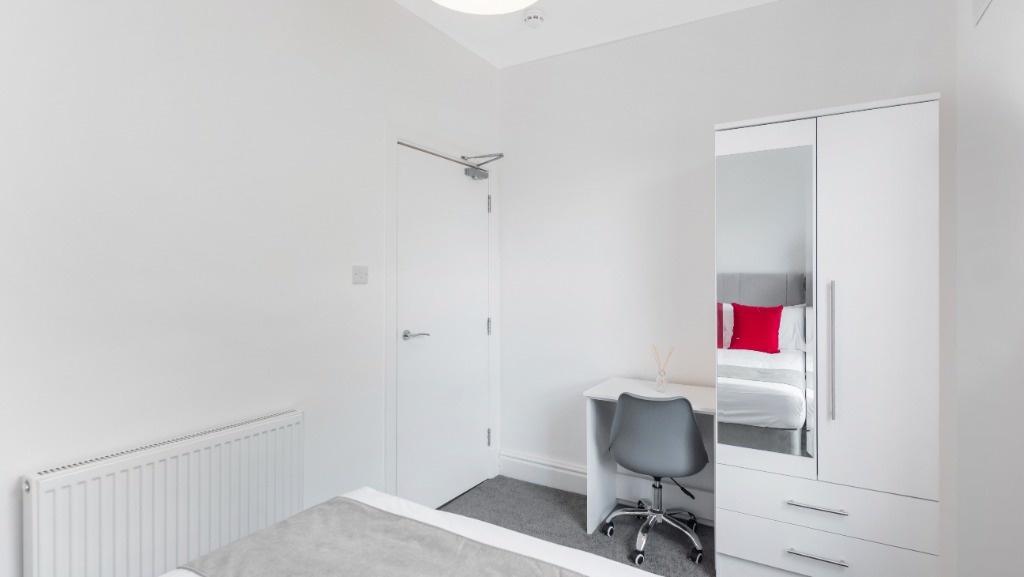 This inviting double bedroom features a cozy at...
