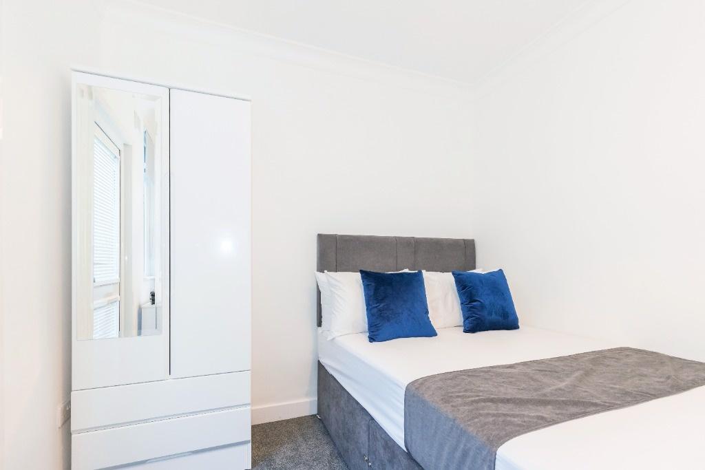 A bright and clean double bedroom featuring a c...
