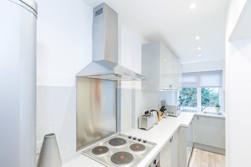Bright and modern kitchen with sleek white cabi...