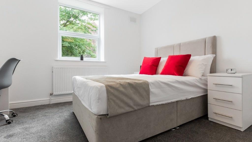 This stylish double bedroom features a comforta...