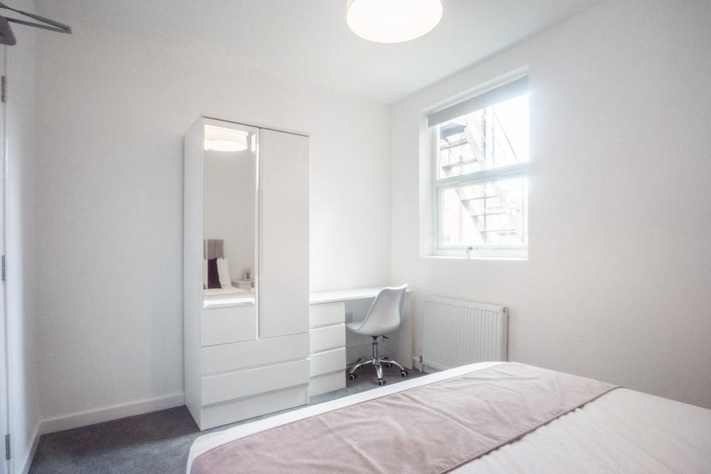This inviting double bedroom features a comfort...