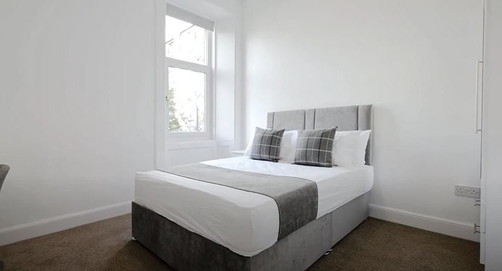 This cozy double bedroom features ample natural...