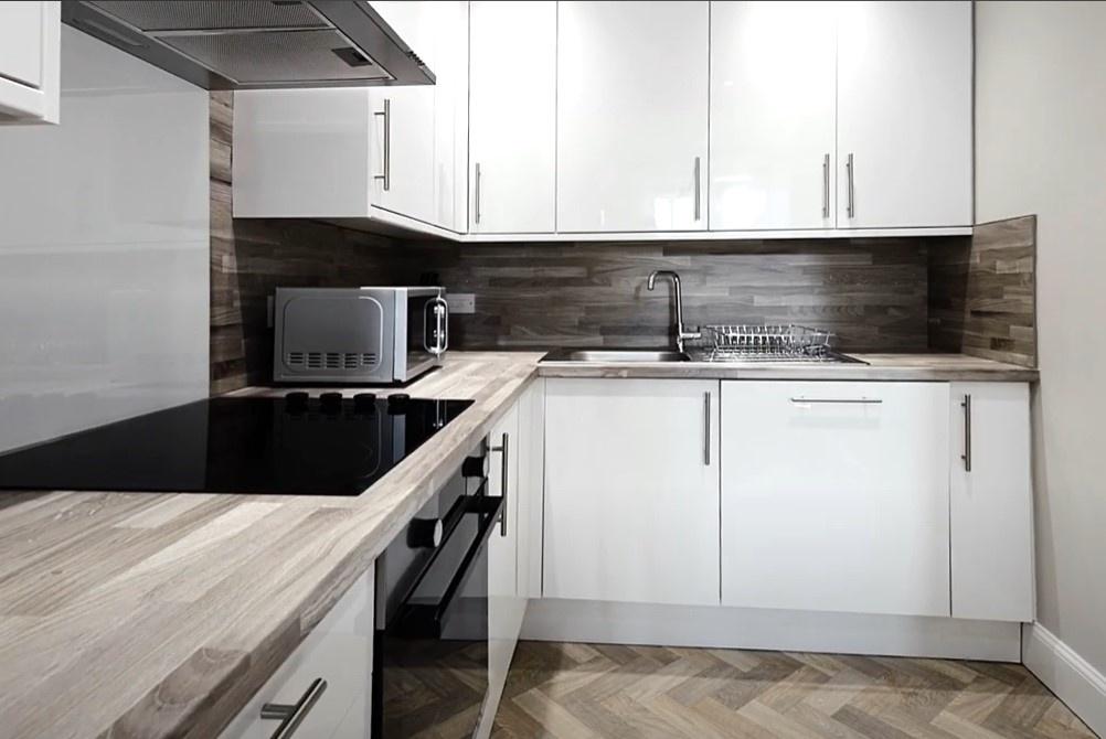Modern kitchen featuring sleek cabinetry, ample...