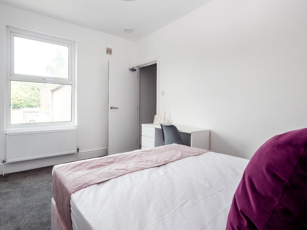 A neat and bright bedroom featuring a comfortab...