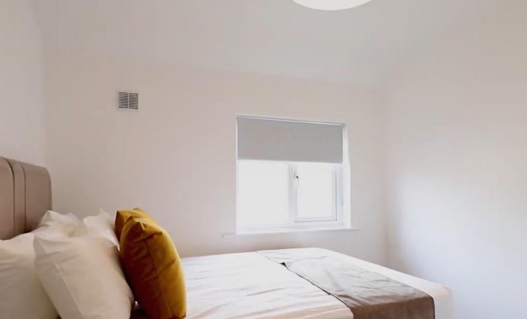 Bright and clean master bedroom featuring a com...