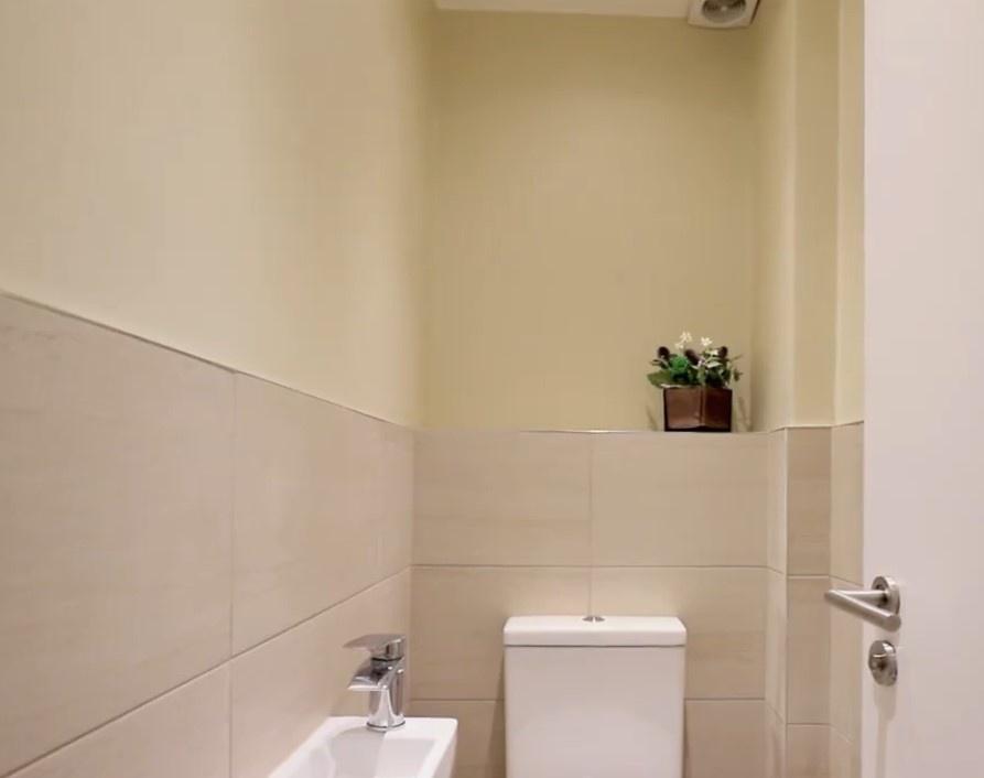 A clean and neatly maintained single toilet wit...
