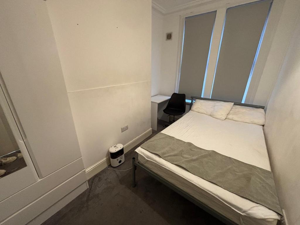 Cozy double bedroom featuring ample natural lig...