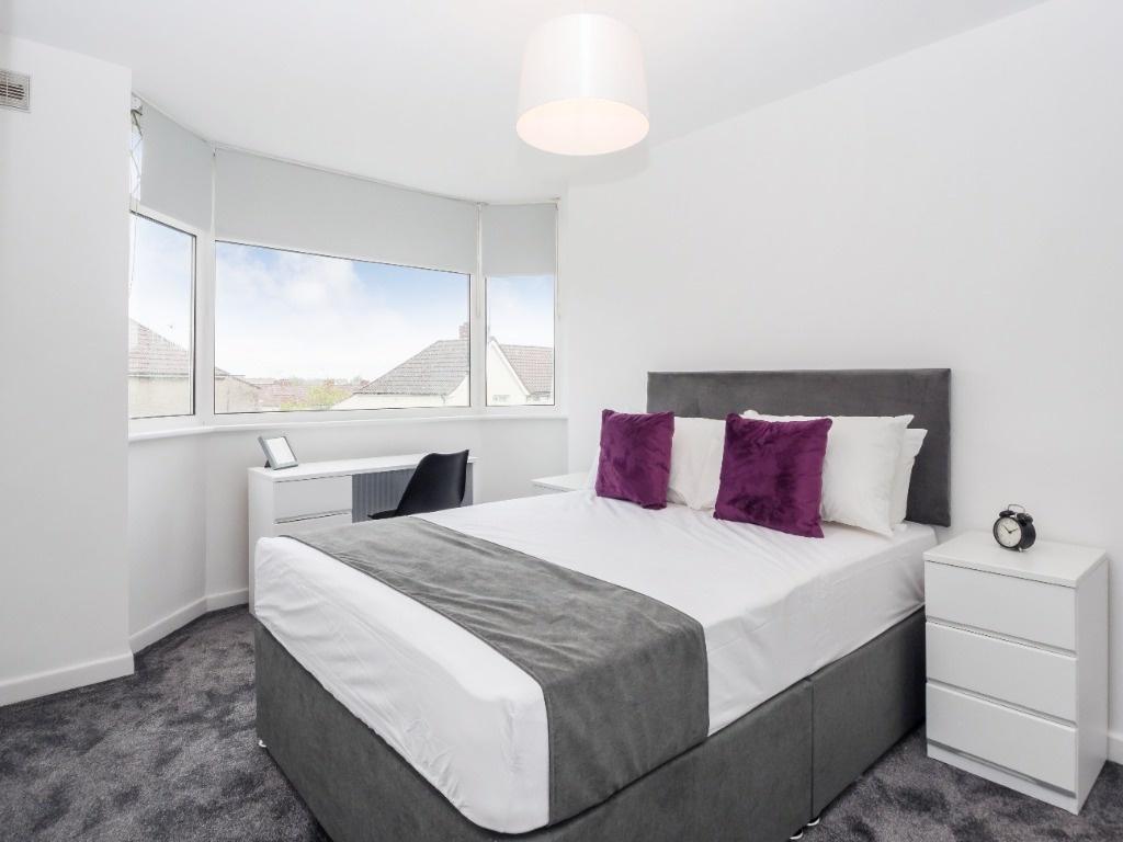 This stylish double bedroom features large wind...